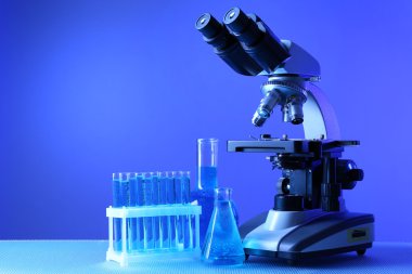 Mikroskop ve masaya renk arka plan üzerinde test tüpleri