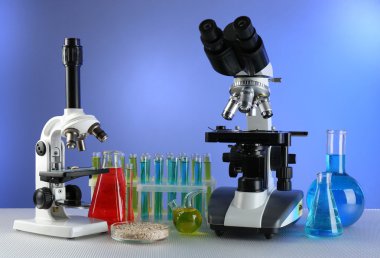 Mikroskoplar, Petri kabına tahıl ve masaya renk arka plan üzerinde test tüpleri ile