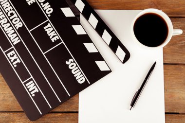 Kağıt, kalem ve kahve ahşap plakalar arka plan üzerinde film tokmağı