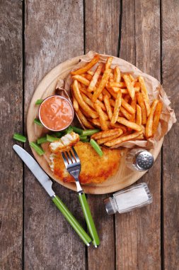 Kızarmış Balık filetosu ve kuşkonmaz ve sos kesme tahtası ve rustik ahşap arka plan ile patates tava