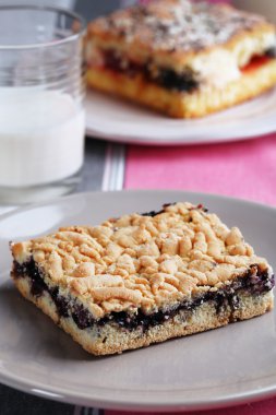 Reçel ve çizgili masa örtüsü arka plan üzerinde süt ile ev yapımı börek