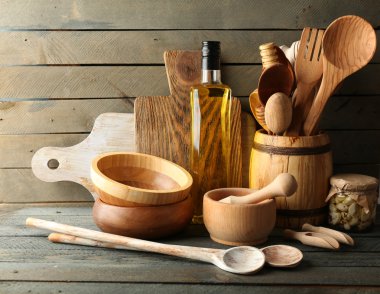 Ahşap mutfak gereçleri ile cam şişe zeytinyağı ahşap plakalar arka plan üzerinde