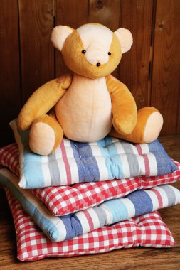 Yastıklar ahşap arka plan üzerinde oyuncak ayı