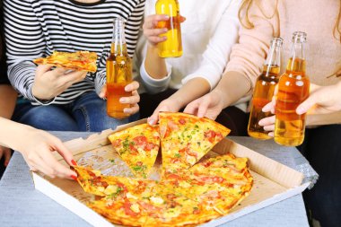 Arkadaşlar el ile şişe bira ve pizza, yakın çekim