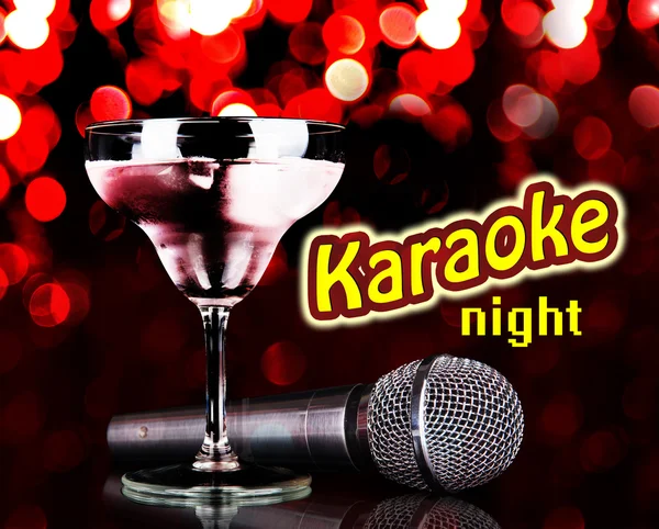 Silver microphone and cocktail on table on red lights background, Karaoke concept — Stock Photo, Image