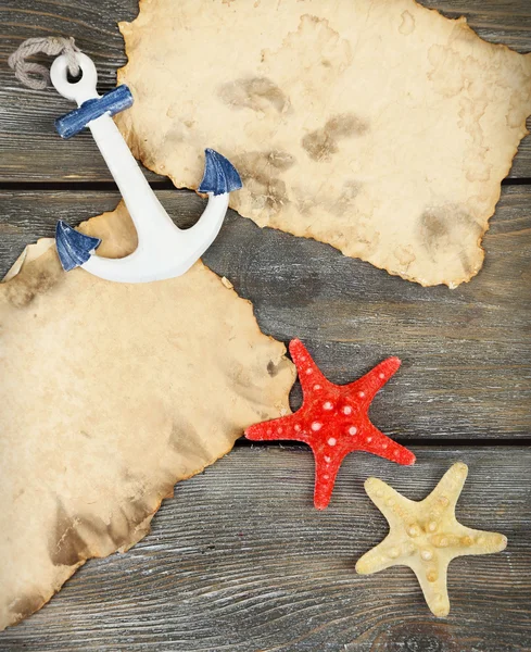 Decor of seashells, starfish and old paper on wooden table background — Stock Photo, Image