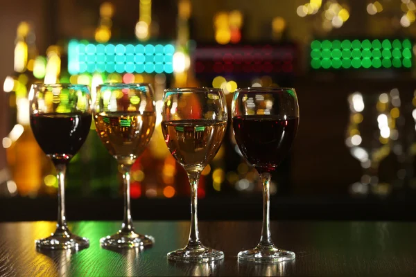 Glasses of wine on counter and bar on background — Stock Photo, Image