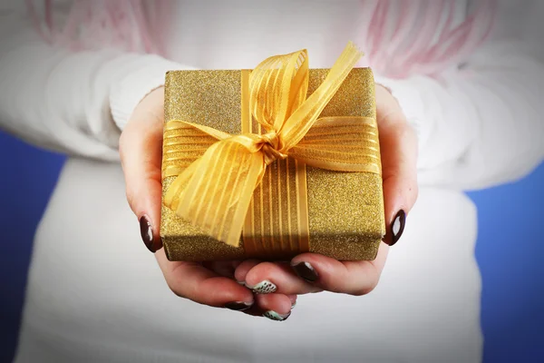 Caja de regalo en mano femenina sobre fondo de color — Foto de Stock