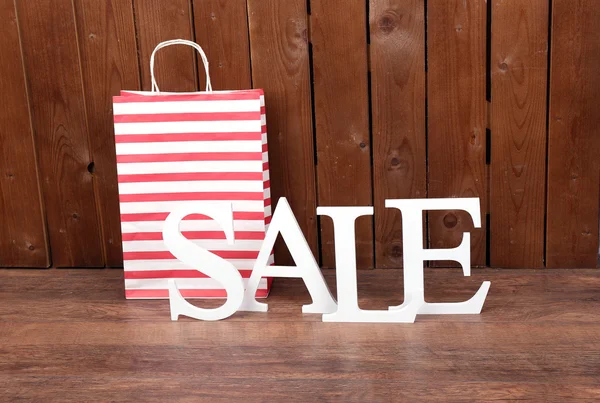 Sale with bags on wooden background — Stock Photo, Image