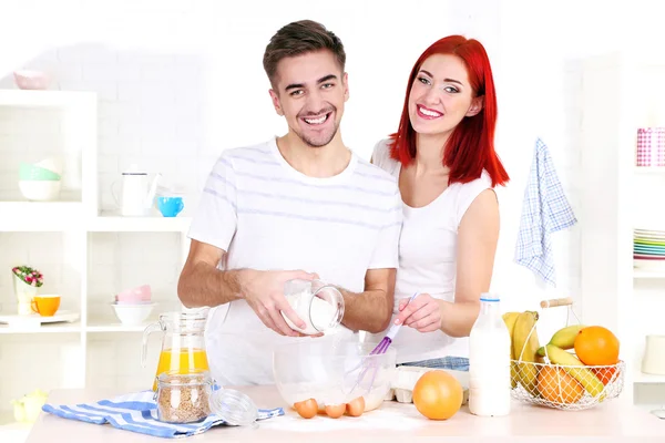 Happy couple preparing dough baking in kitchen — Stock Photo, Image