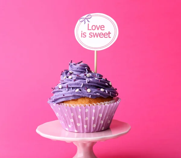 Delizioso cupcake con iscrizione su sfondo rosa — Foto Stock