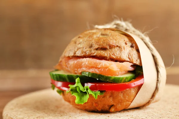 Sandwich con salmón sobre fondo de madera — Foto de Stock