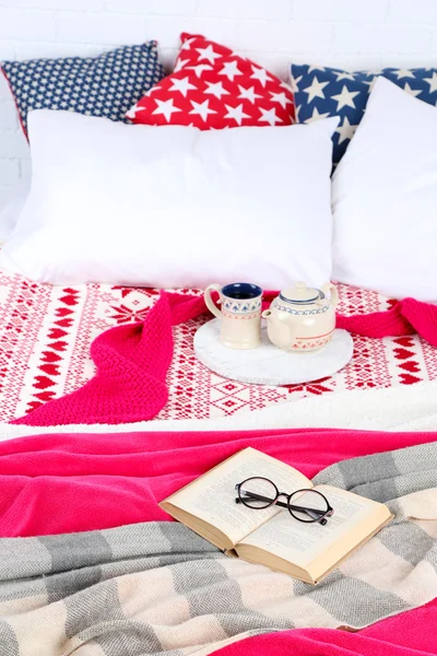 Book and tea on bed close-up — Stock Photo, Image