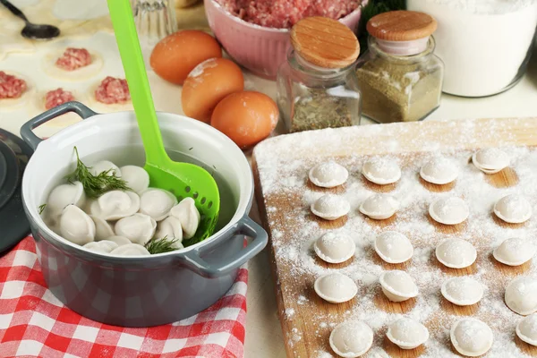 Raw and cooked dumplings close-up in kitchen — Stock Photo, Image