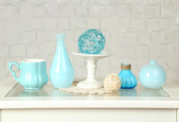 Interior con jarrones decorativos en la mesa y fondo de pared de ladrillo blanco — Foto de Stock