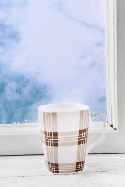 Kopje warme drank op vensterbank op regen achtergrond — Stockfoto