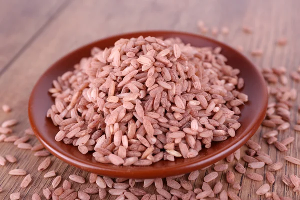 Arroz rojo en plato sobre fondo de madera — Foto de Stock