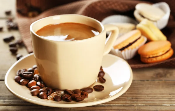 Sanfte bunte Makronen und Kaffee im Becher auf Holztischhintergrund — Stockfoto