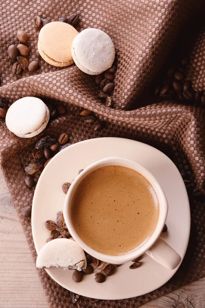 Makaroni yang lembut dan berwarna-warni dan kopi dalam cangkir pada latar belakang meja kayu — Stok Foto