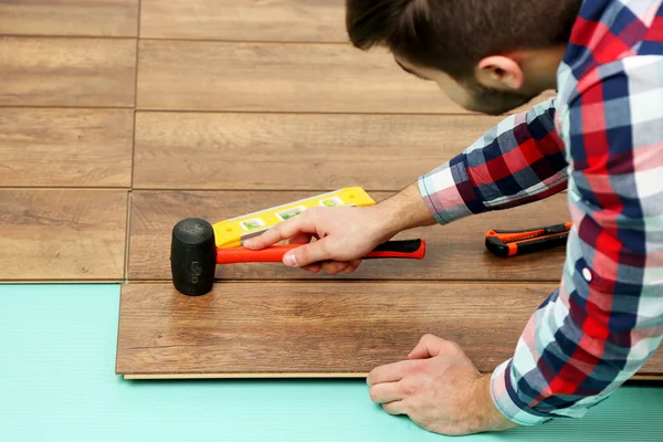 Travailleur charpentier installant un plancher stratifié dans la pièce — Photo