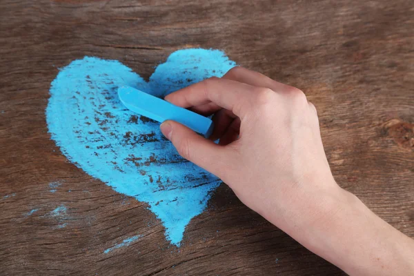 Mano dibuja corazón de tiza en tablero de madera — Foto de Stock