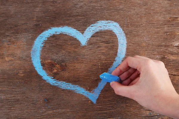 Mano dibuja corazón de tiza en tablero de madera — Foto de Stock