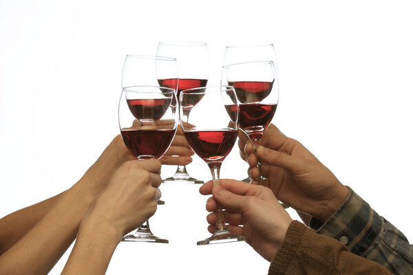 Clinking glasses of red wine in hands isolated on white