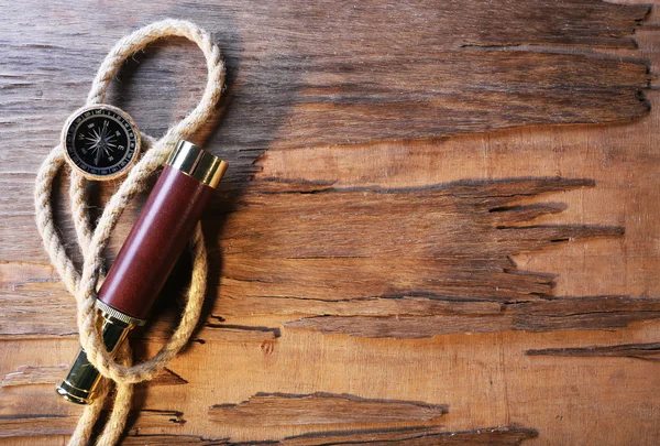 Marine still life spyglass, compass and rope on wooden background — Stock Photo, Image