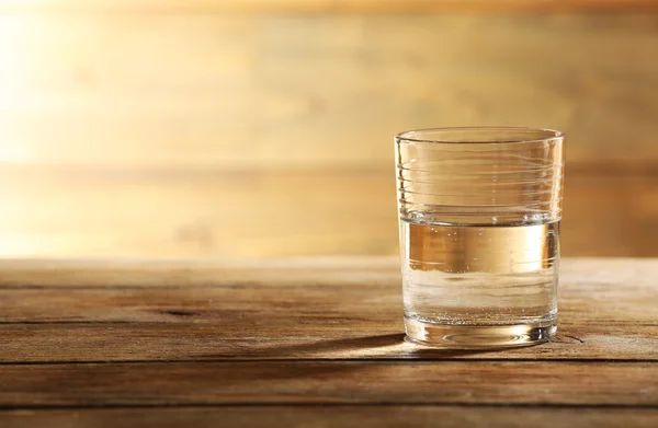 Vidro de água mineral limpa na superfície e no fundo — Fotografia de Stock