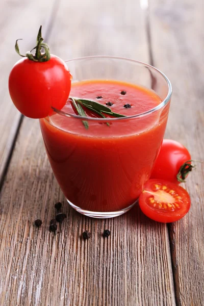 Tomato juice in glass with pepper and rosemary on wooden planks background — Stock Photo, Image