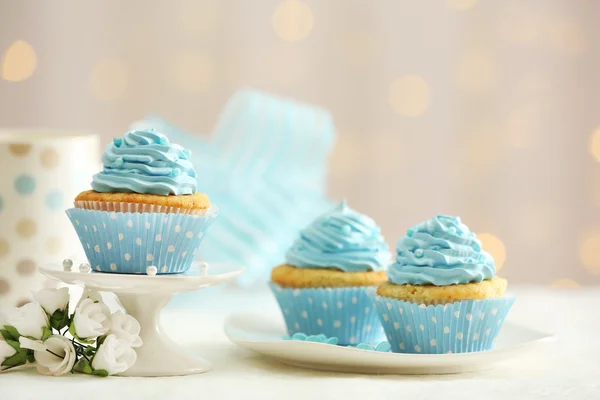 Deliciosos cupcakes en la mesa sobre fondo claro — Foto de Stock