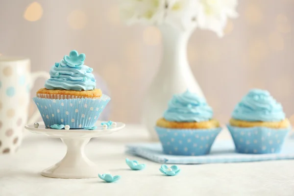 Leckere Cupcakes auf dem Tisch auf hellem Hintergrund — Stockfoto