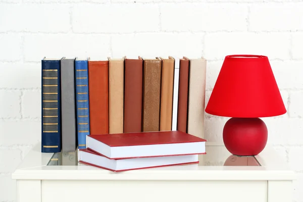 Books on shelf on wall background — Stock Photo, Image