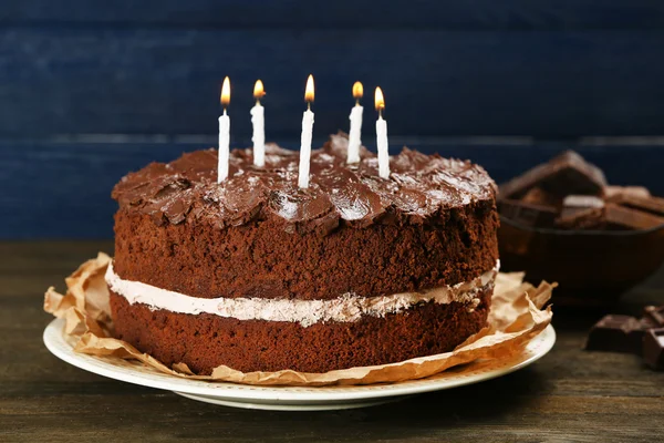 Delicioso pastel de chocolate en la mesa sobre fondo azul —  Fotos de Stock