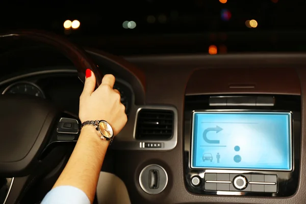 Mujer conduciendo su coche moderno por la noche en la ciudad, primer plano — Foto de Stock