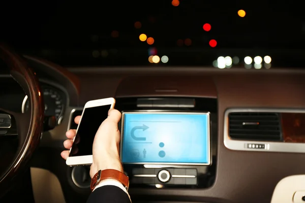 男人到了晚上，驾车时使用智能手机特写 — 图库照片