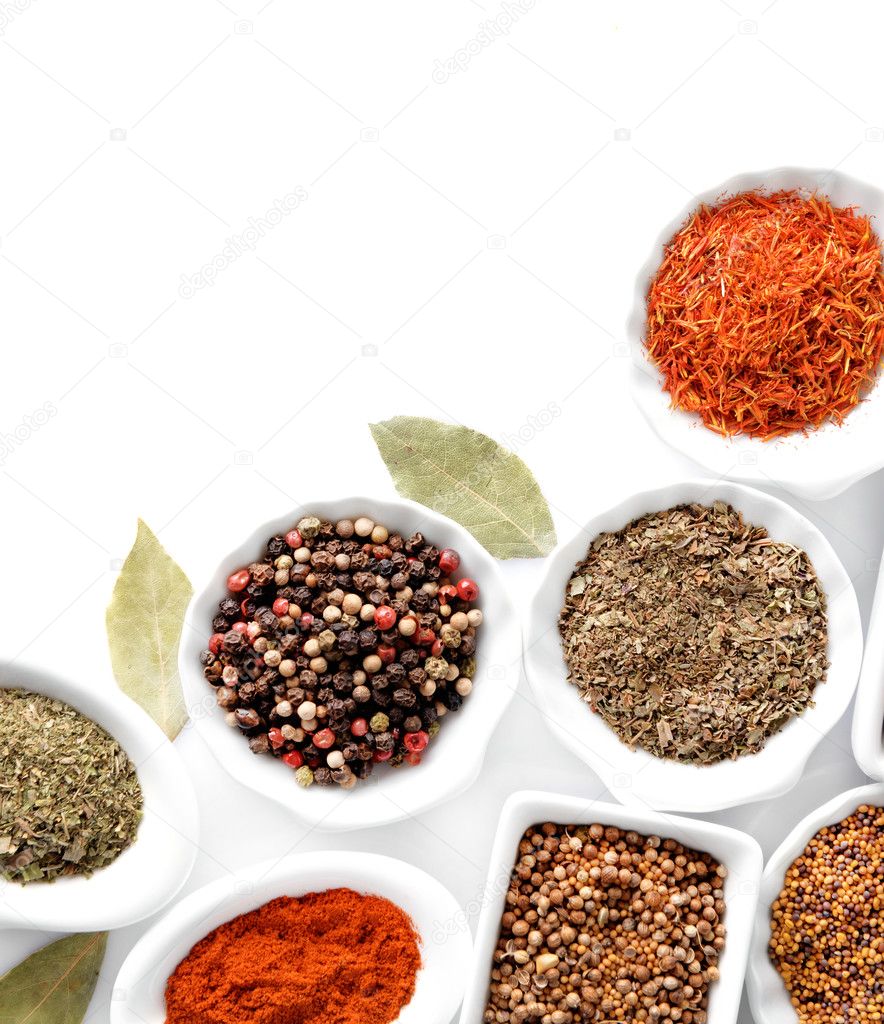 Different kinds of spices in ceramics bowls isolated on white