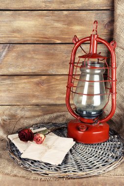 Gaz lambası kurutulmuş gül desenli ve mektup hasır mat ve ahşap plakalar arka plan