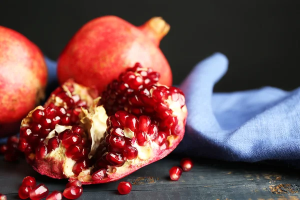 Saftige reife Granatäpfel auf Holztisch, vor dunklem Hintergrund — Stockfoto