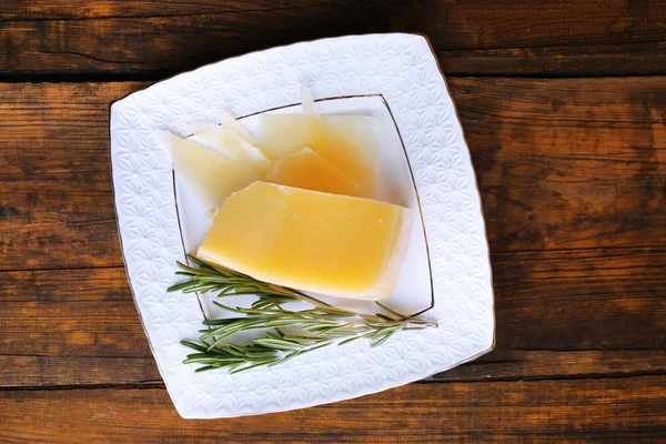 Fromage parmesan avec brin de romarin sur fond de table en bois — Photo