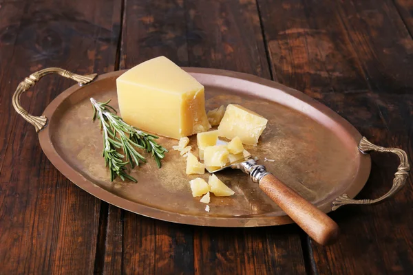 Brokkelt Parmezaanse kaas met takje rozemarijn en blad op metalen lade op houten tafel achtergrond — Stockfoto