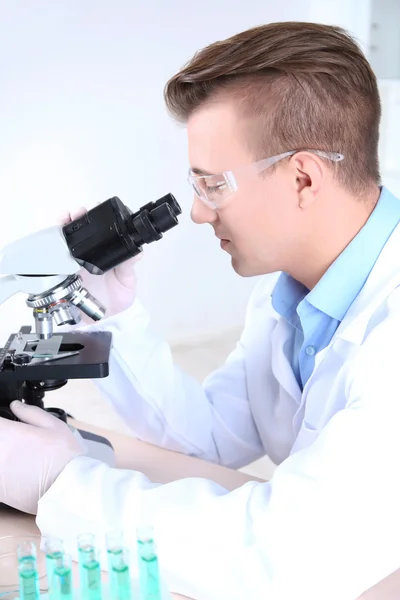 研究室で顕微鏡を使う男性科学者 — ストック写真