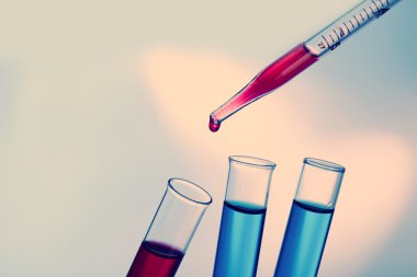 Pipet sıvı test tüpleri parlak arka plan üzerinde bir ekleme