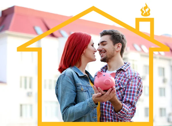 Verliefde paar met piggy bank in de buurt van appartement huis — Stockfoto