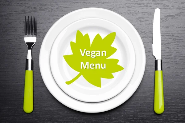 Skylt med texten "Vegan Menu", gaffel och kniv på tabellbakgrund — Stockfoto