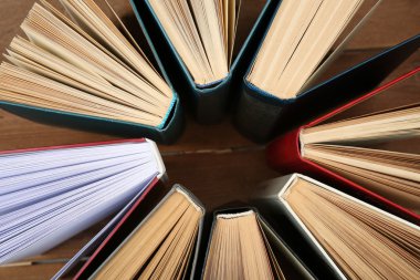Tahta zemin üzerinde kitap grubu, üst görünüm