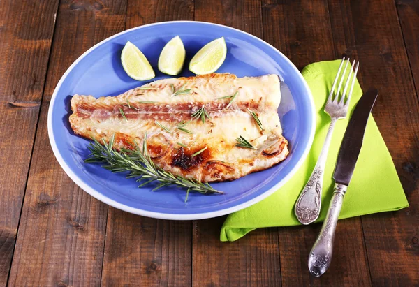 Dish of Pangasius fillet with rosemary and lime on wooden table background — Stock Photo, Image