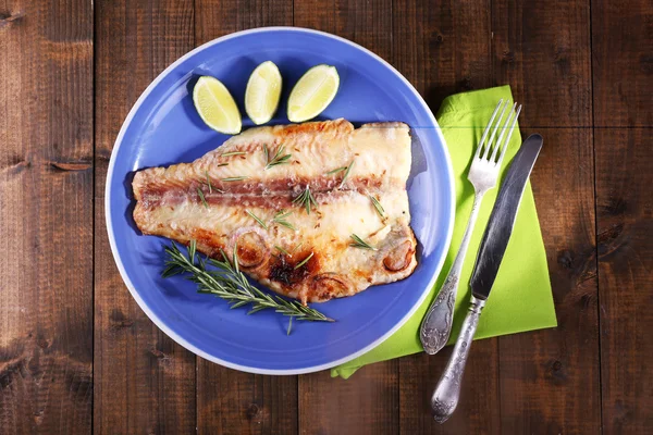 Schotel van Pangasius filet met rozemarijn en kalk op houten tafel achtergrond — Stockfoto