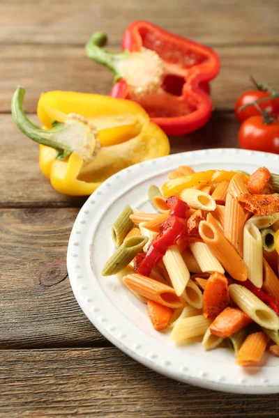 Salade de pâtes au poivre, carotte et tomates sur fond de table en bois — Photo