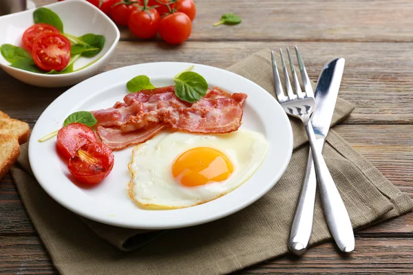 Bacon e ovos em tábuas de madeira rústica fundo — Fotografia de Stock